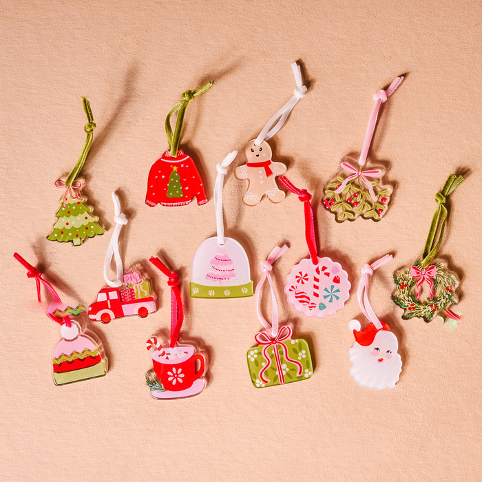 The Darling Effect's Classic Christmas Ornament Advent Calendar includes mini ornaments like a red sweater, gingerbread man, mistletoe, wreath, truck, hot cocoa mug, and more—perfect for artificial trees or countdown calendars.