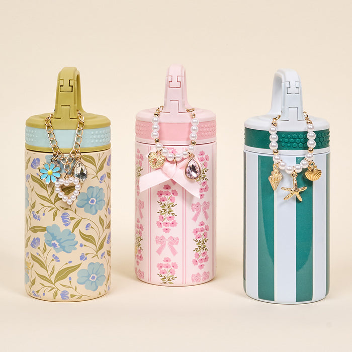 Three tumblers by The Darling Effect feature floral, bow, and striped pastel designs with decorative lids and handles—perfect for displaying your Simply Coquette Tumbler Charm or favorite drinkware accessories.