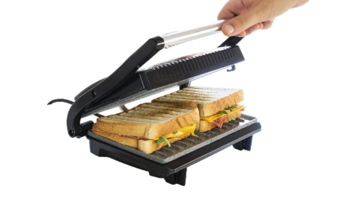 Sandwich maker with sandwiches being prepared on a white background
