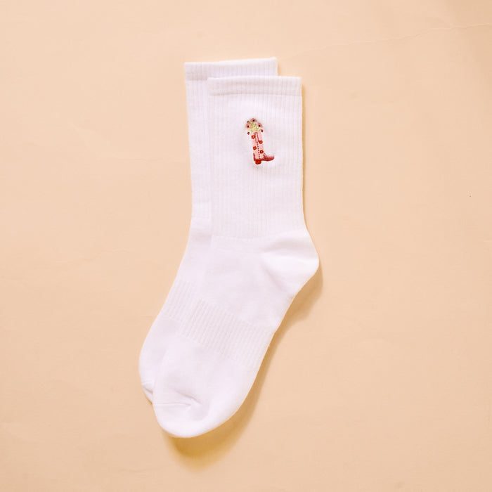 The Darling Effect Cowgirl Boot Embroidered Crew Socks are white women's socks made from breathable fabric, featuring a red cowboy boot embroidery on the side.