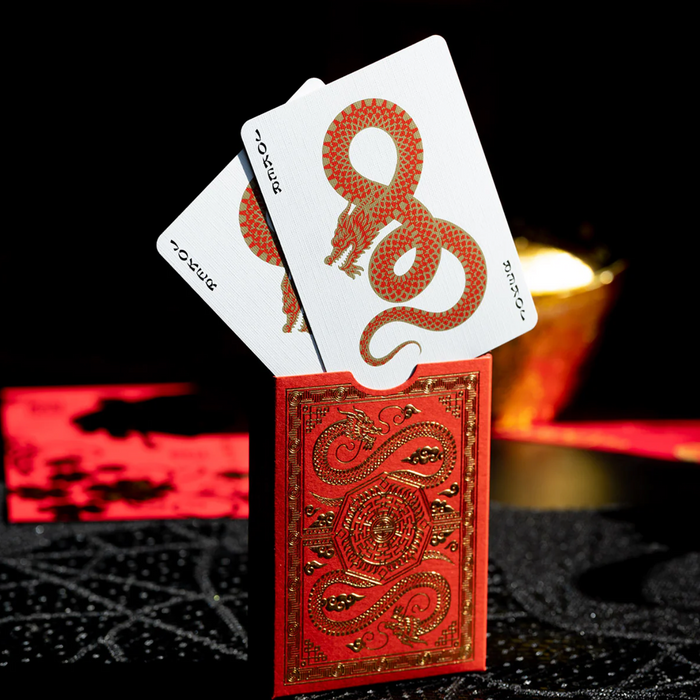 Red and gold playing cards with a dragon design on a black background