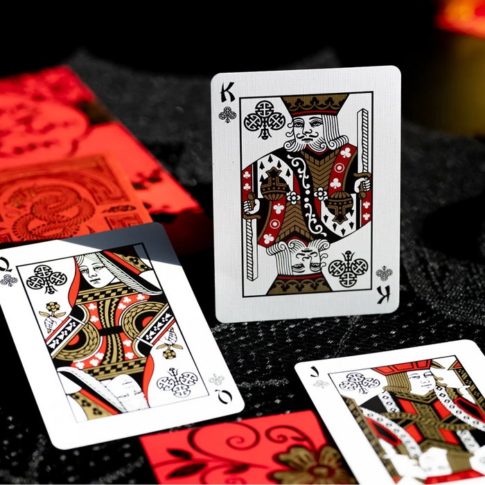 Playing cards with King and Queen of Clubs on a dark surface