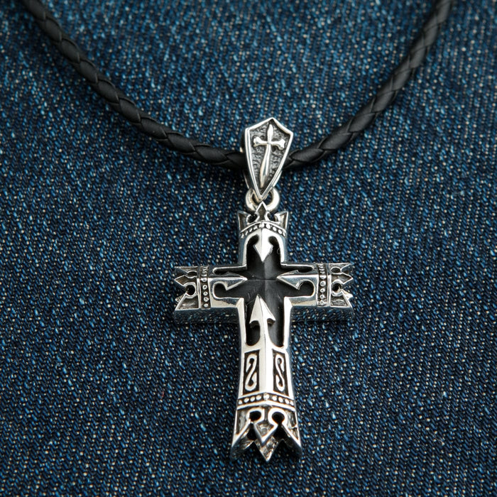 A front view of the sterling silver guardian knight cross pendant, featuring a central black onyx stone and gothic engravings.