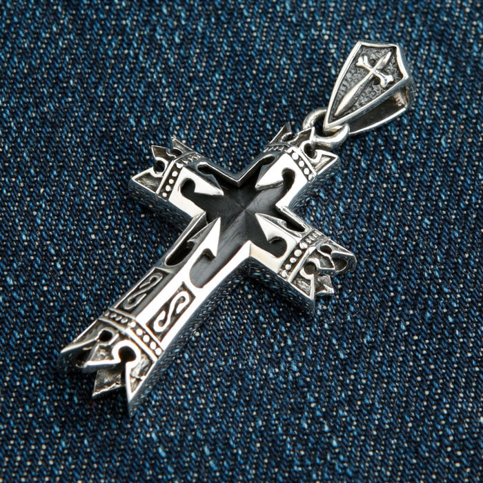A side profile of the heavy silver and onyx pendant, highlighting the intricate band carvings.