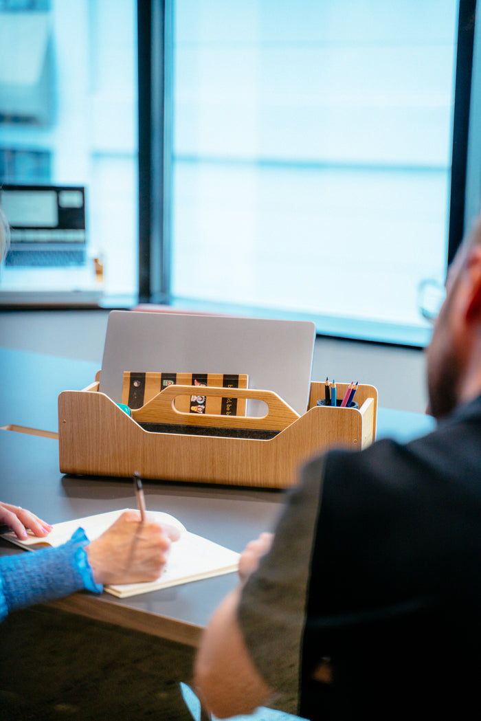 Gustav Dot oak wood desk organizer on a shared workspace desk