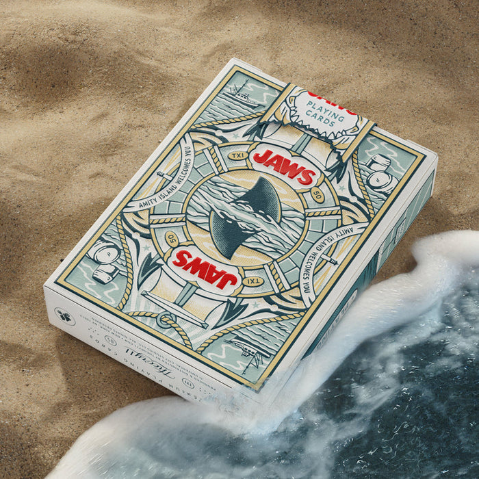 Jaws playing cards tuck box on sand with ocean wave
