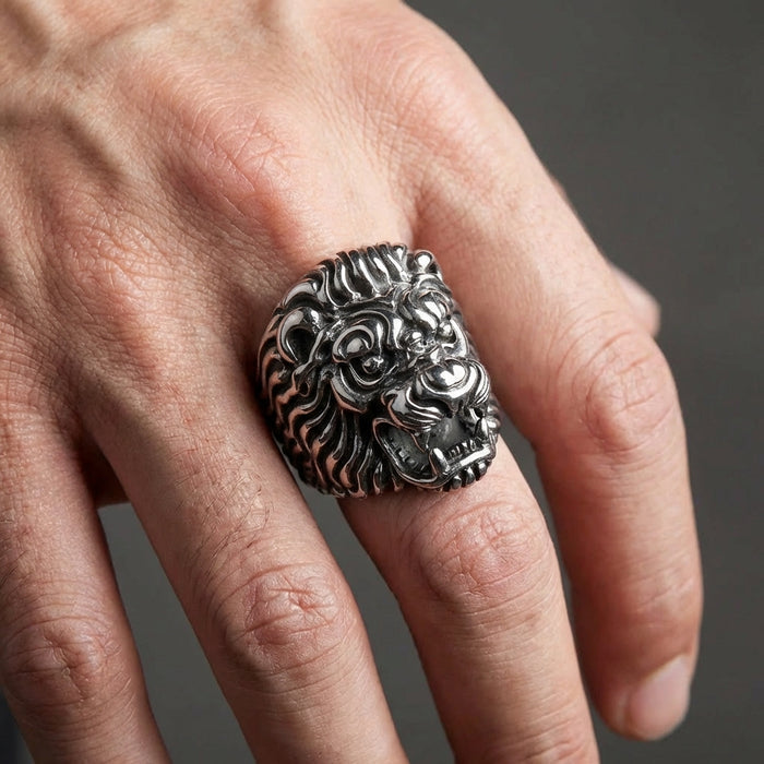 A model's hand wearing the large sterling silver lion head biker ring to demonstrate its impressive and substantial scale.