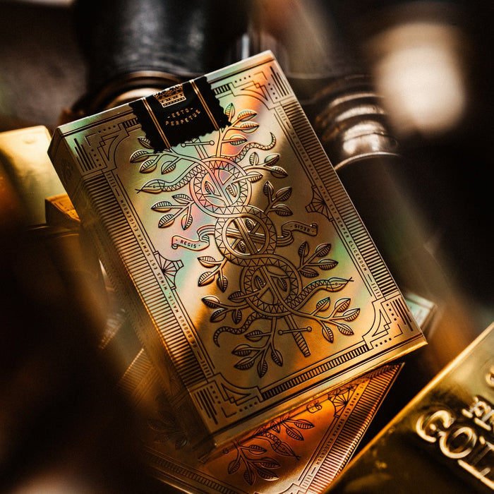 Gold playing cards with intricate designs on a blurred background