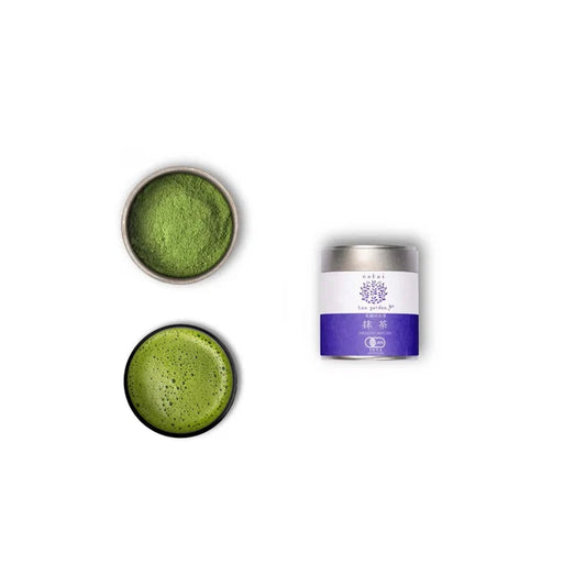 A tin container of Wazuka Tea Nakai Superior next to a bowl and a dish of matcha powder