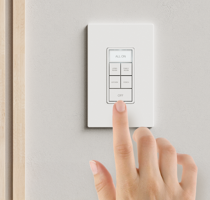 A hand pressing a button on a lighting keypad